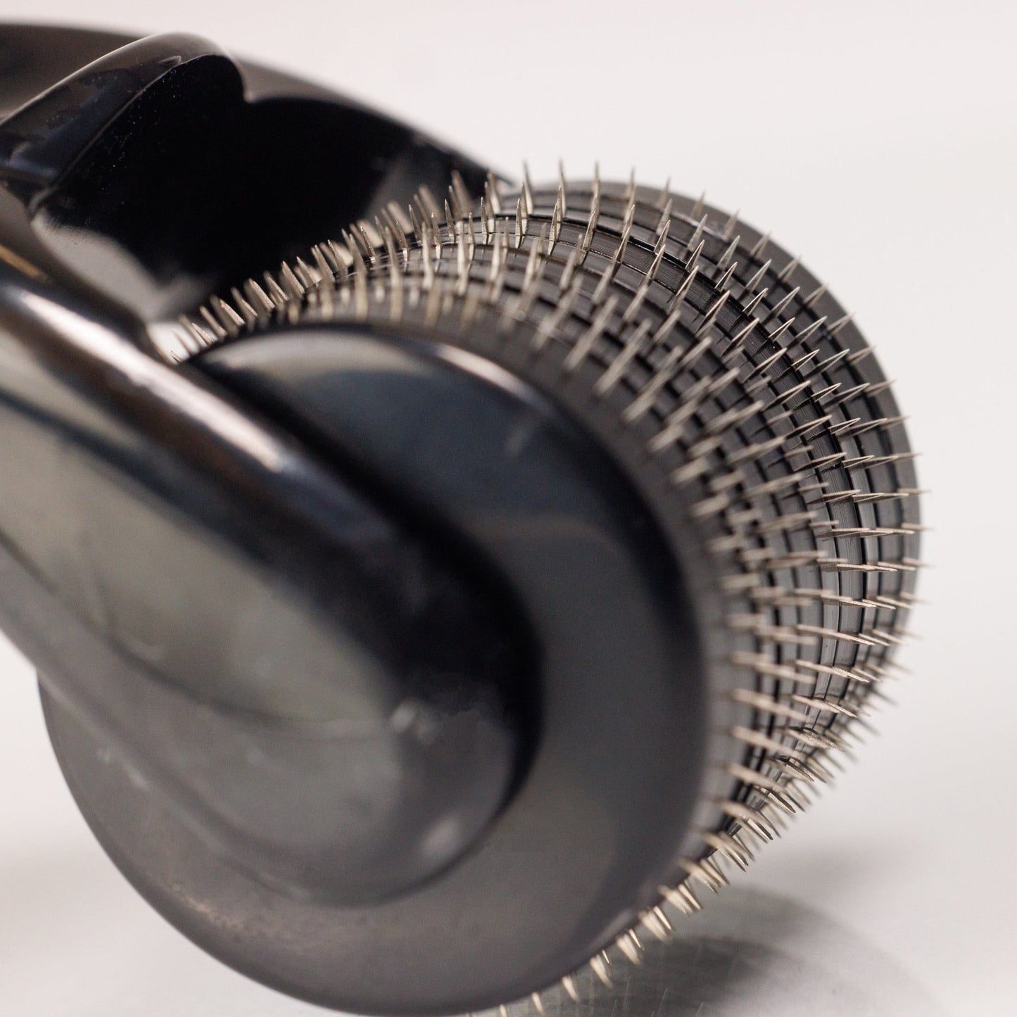 Nahaufnahme des Dr. Balwi Dermarollers aus dem Dr. Balwi Shop mit vielen winzigen Metallnadeln auf einem zylindrischen Roller, der für Hautpflegebehandlungen und Microneedling zur Unterstützung des Haarwachstums entwickelt wurde.
