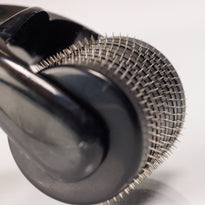 Nahaufnahme des Dr. Balwi Dermarollers aus dem Dr. Balwi Shop mit vielen winzigen Metallnadeln auf einem zylindrischen Roller, der für Hautpflegebehandlungen und Microneedling zur Unterstützung des Haarwachstums entwickelt wurde.
