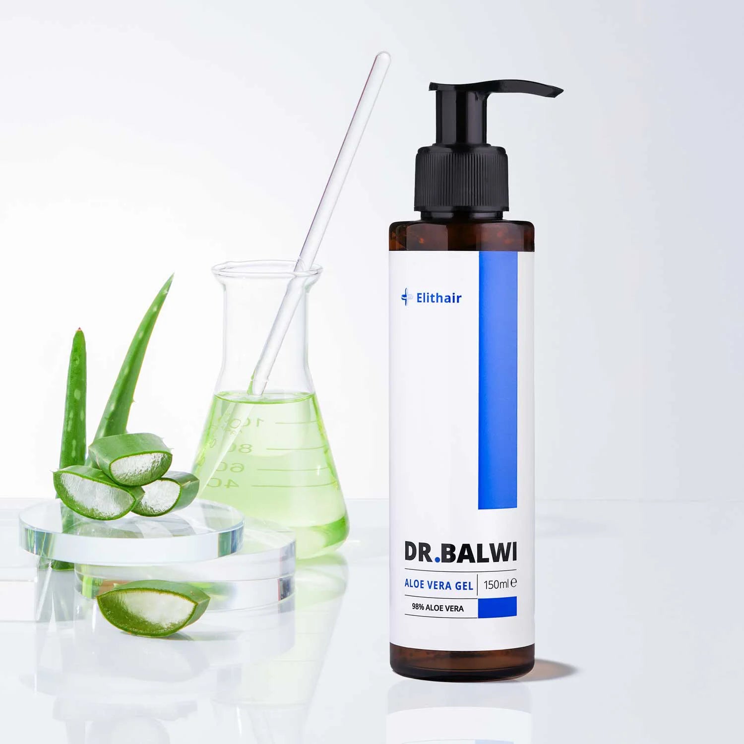 Eine Flasche Dr. Balwi Shop's 98% Aloe Vera steht neben Aloe-Blättern, einer Glasschale mit Aloe-Scheiben und einem Becher mit grüner Flüssigkeit - ideal für intensive Feuchtigkeitspflege Haar und sanfte Kopfhautpflege.