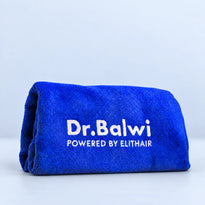 Ein gefaltetes blaues Mikrofaser-Kopfhandtuch aus dem Dr. Balwi Shop mit der Aufschrift Dr. Balwi POWERED BY ELITHAIR in weißer Stickerei auf der Vorderseite.